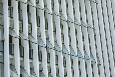 Close up of the facade of an office building in London with vertical slats and large windows, white color palette, daylight, architectural photography, architectural detail in the style of architectural detail. --ar 128:85