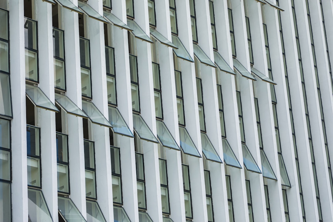 Close up of the facade of an office building in London with vertical slats and large windows, white color palette, daylight, architectural photography, architectural detail in the style of architectural detail. –ar 128:85