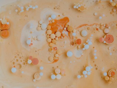 A photo of orange and white paint bubbles in beige milk, with swirls and patterns in an aerial view, in the style of abstract art. --ar 4:3