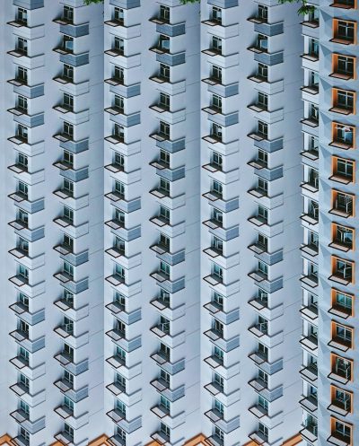 Photograph of the facade of an apartment building in Hong Kong, with balconies and railings, symmetrical grid arrangement, minimalist architecture photography in the style of white background, straight lines, symmetrical composition, highly detailed, high resolution, hyper realistic, detailed. --ar 103:128