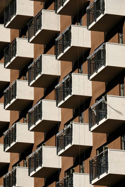 A photograph of apartment balconies arranged in a symmetrical pattern, architectural photography, archdaily, architectural detail, beige and brown. The photograph shows balconies arranged in the style of architectural photography for archdaily, with an architectural detail in beige and brown colors. --ar 85:128