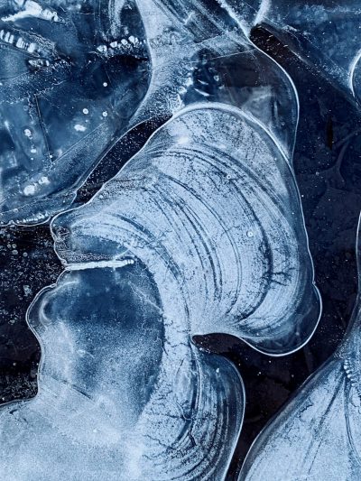 a close up of an ice sheet with the shape of human ears carved into it, dark blue color palette, high detail, photo realistic --ar 3:4