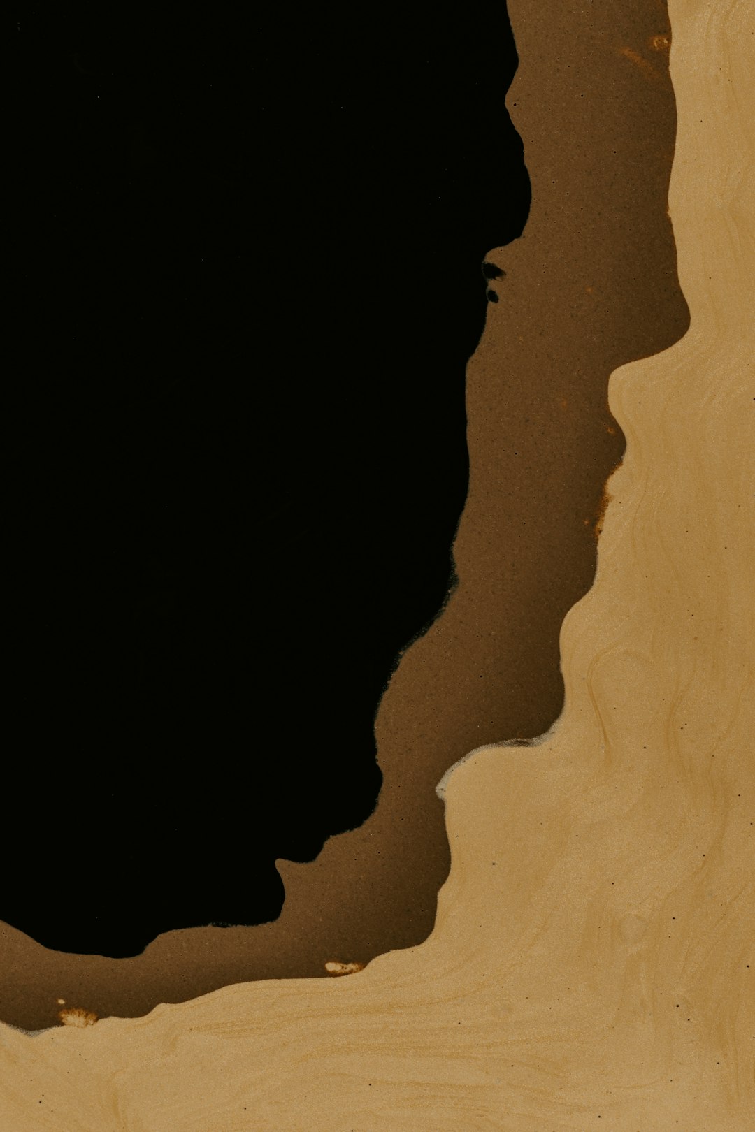 Extreme close up of an edge silhouette on the left side of beige wood grain with a black background, only showing the shape of a person’s head and shoulders, ink drawing in the style of minimalist, flat illustration, warm tones, low contrast. –ar 85:128