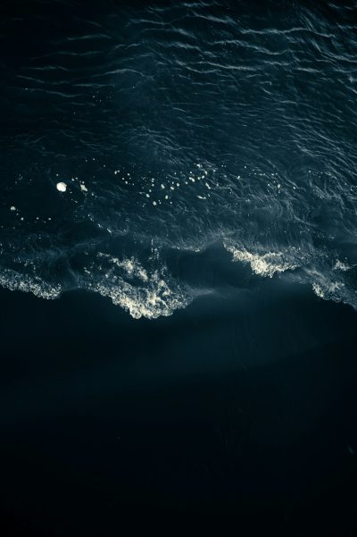 a dark ocean with waves, seen from above, top view, night time, moonlight, photo realistic, hyper detail cinematic lighting --ar 85:128