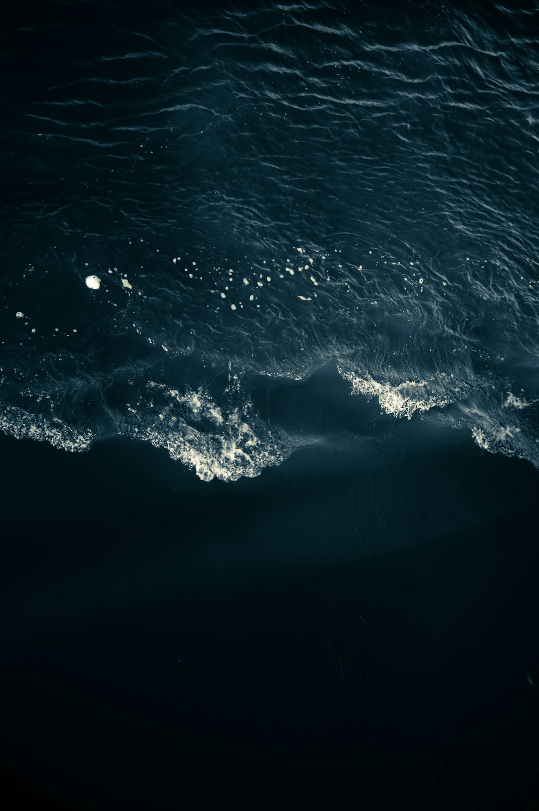 a dark ocean with waves, seen from above, top view, night time, moonlight, photo realistic, hyper detail cinematic lighting –ar 85:128