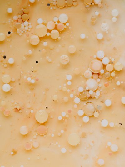 An editorial minimalistic photo of an abstract with many tiny white, black and pastel peach colored bubbles floating in the air on top of beige milk, close up shot. The composition is symmetrical with an empty background, in the style of [Rineke Dijkstra](https://goo.gl/search?artist%20Rineke%20Dijkstra). --ar 3:4