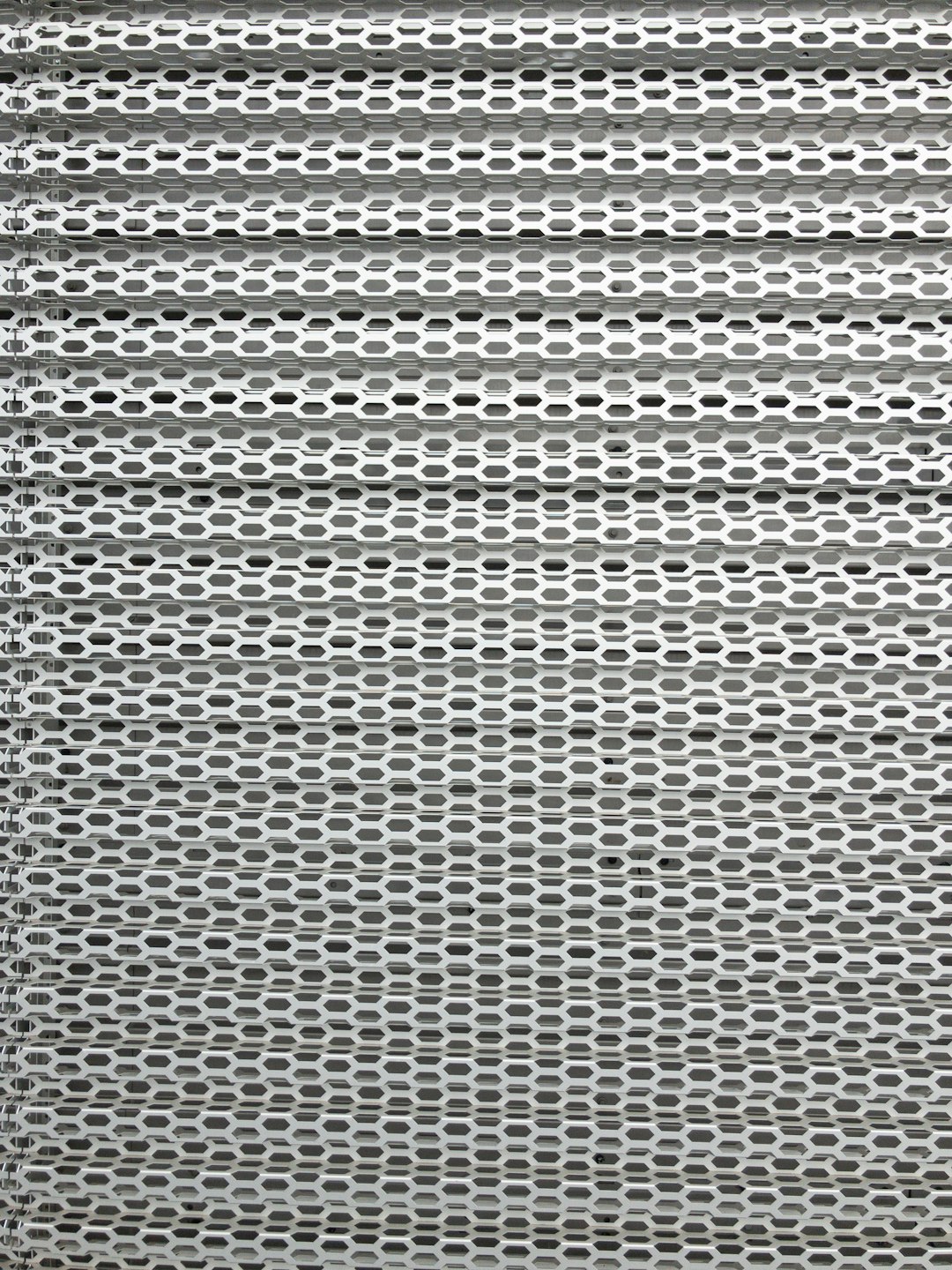 a close up of the texture of an aluminum mesh screen, flat gray background, white grid pattern, front view, symmetrical, studio photography, high resolution –ar 3:4