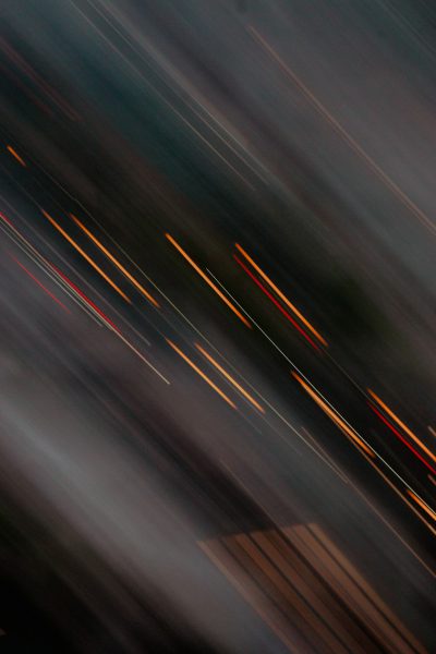 A blurry photo of moving lights on the road, captured with long exposure photography technique. The light trails create an abstract and dynamic composition, adding movement to the scene. This style is suitable for conveying motion or speed in various applications like street scenes, traffic circles, and other environments where blurred effects can be used to represent fast modeling. Focus stacking, double exposure, dark gray background, and blurred edges were used to create a high resolution image in the style of abstract street photography. --ar 85:128