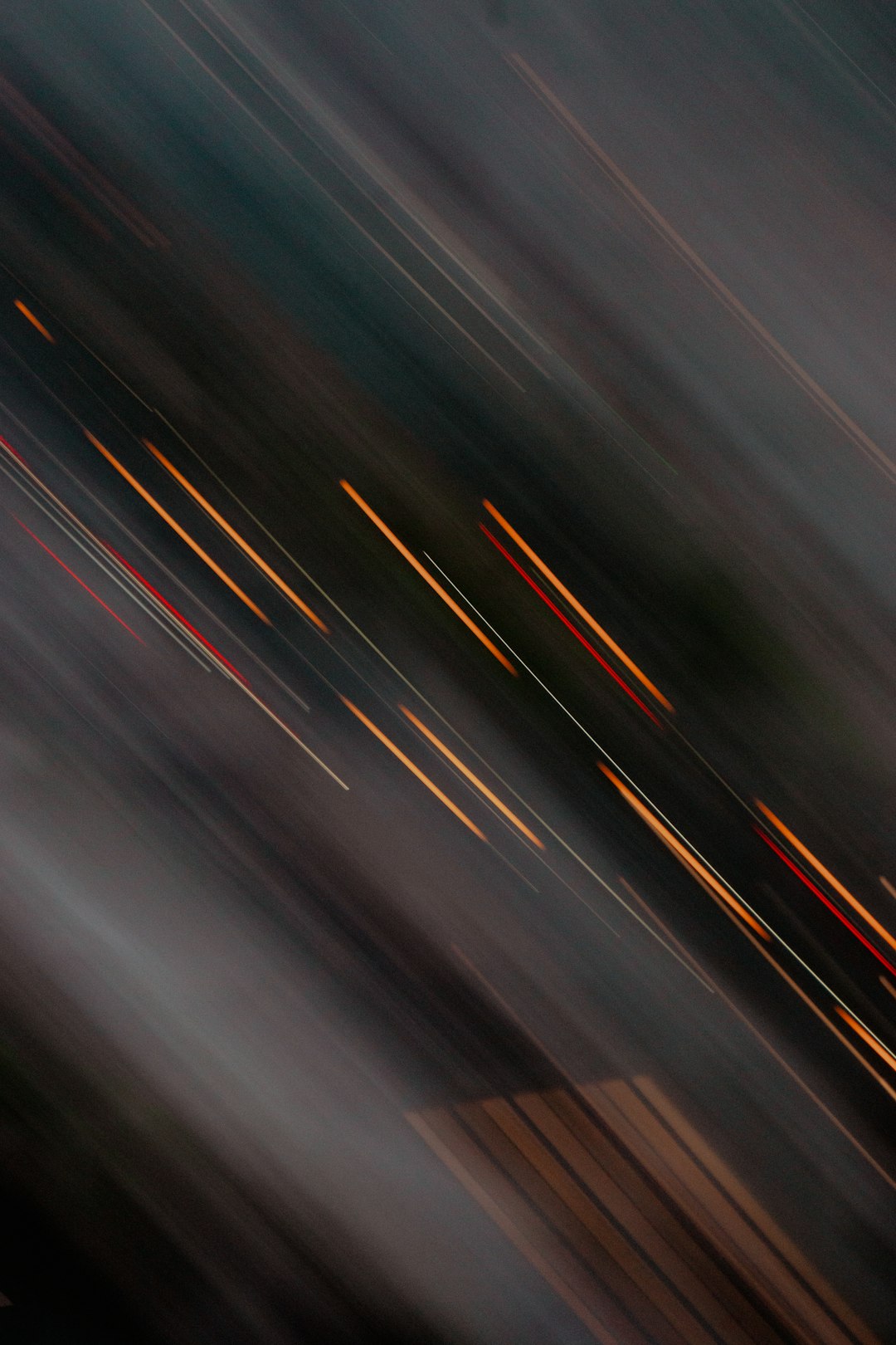 A blurry photo of moving lights on the road, captured with long exposure photography technique. The light trails create an abstract and dynamic composition, adding movement to the scene. This style is suitable for conveying motion or speed in various applications like street scenes, traffic circles, and other environments where blurred effects can be used to represent fast modeling. Focus stacking, double exposure, dark gray background, and blurred edges were used to create a high resolution image in the style of abstract street photography. –ar 85:128