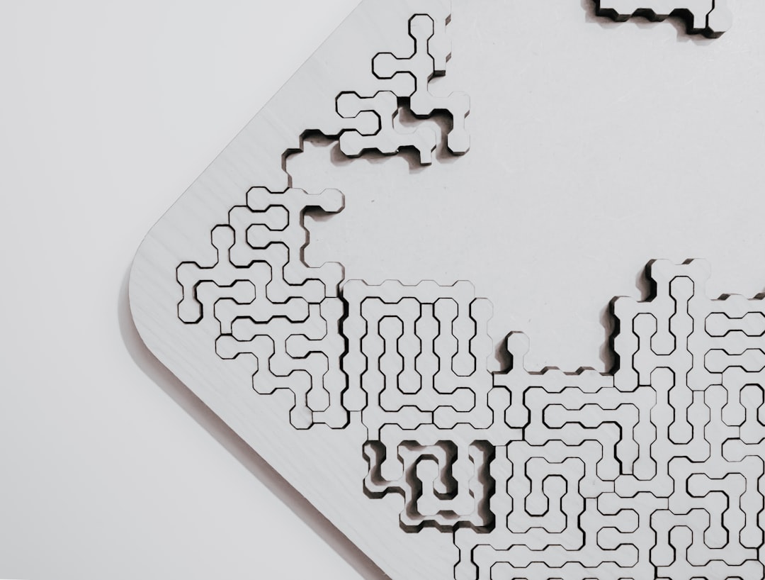 A close up of an empty white puzzle on the table, with geometric patterns, made from laser cut basswood and metal, product photography, on a blank background, in the style of nendo. –ar 128:97