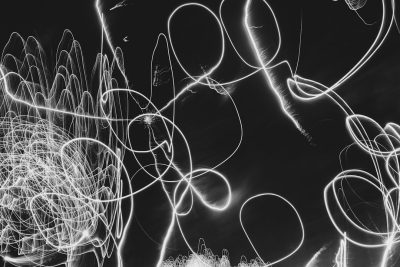 Light painting with a black background, white circles and lines on the left side of the image, chaotic swirls in the foreground in the style of abstract expressionism. --ar 128:85