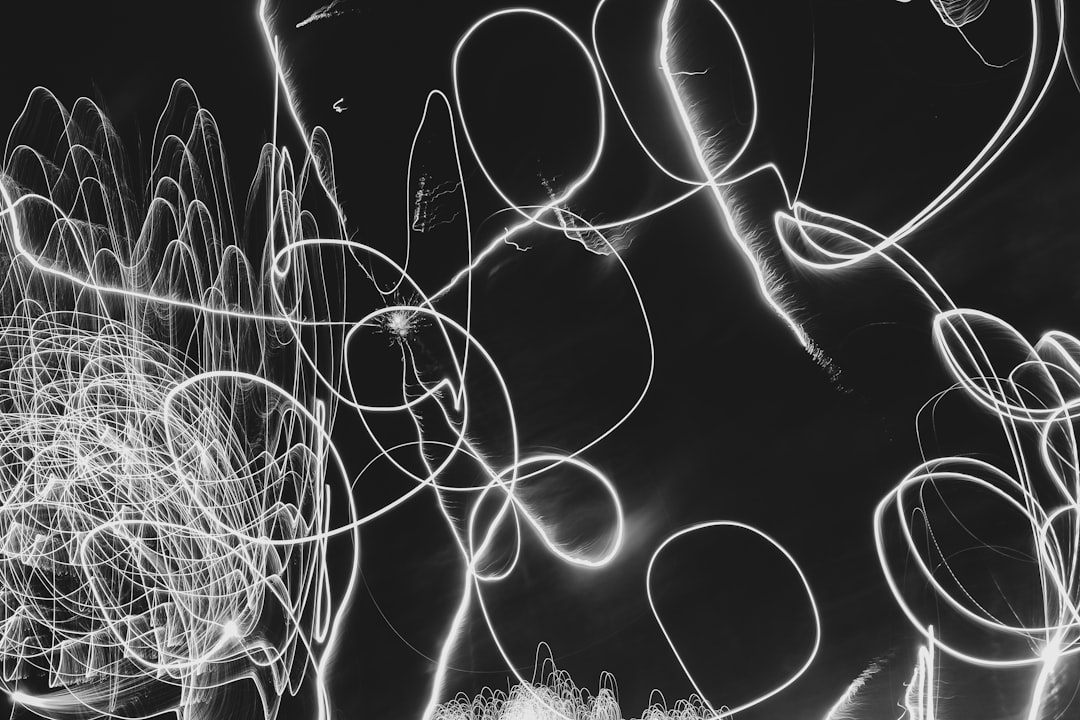 Light painting with a black background, white circles and lines on the left side of the image, chaotic swirls in the foreground in the style of abstract expressionism. –ar 128:85