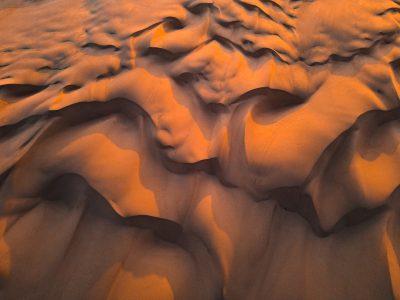 Dune pattern, top view of the desert at sunset, dunes with orange and brown colors, aerial photography, texture background, high resolution, high detail, hyper realistic, sharp focus, extreme long shot, natural light, beautiful, cinematic --ar 4:3