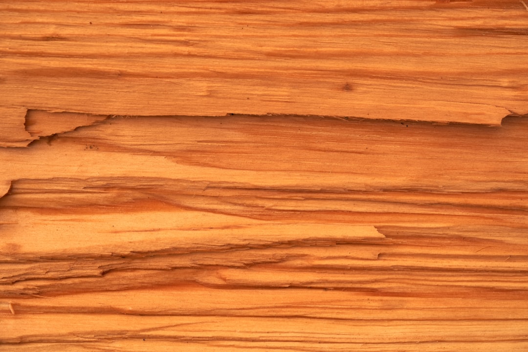 High resolution photo of an old wood wall with cracks and wood grain in the style of Diorama, featuring peach colored wood planks. The focus is on the texture of each wooden surface, capturing its natural beauty. This closeup view highlights every line and ageold marks that give it character. Soft lighting creates gentle shadows to enhance details. –ar 128:85