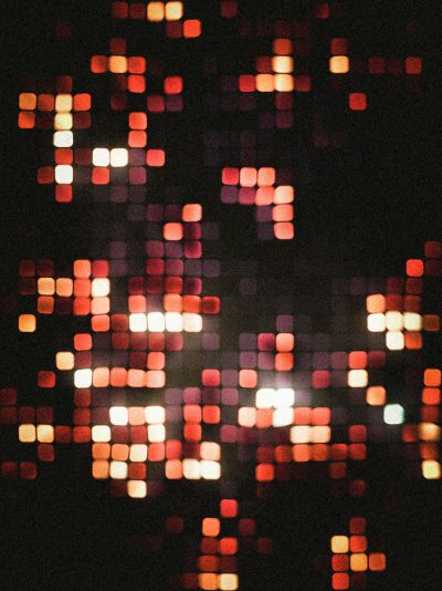 1980s vintage photograph showing red and orange pixelated lights on a black background with a bokeh effect. The image is in the style of pixelated lights typical of the 1980s era. --ar 95:128