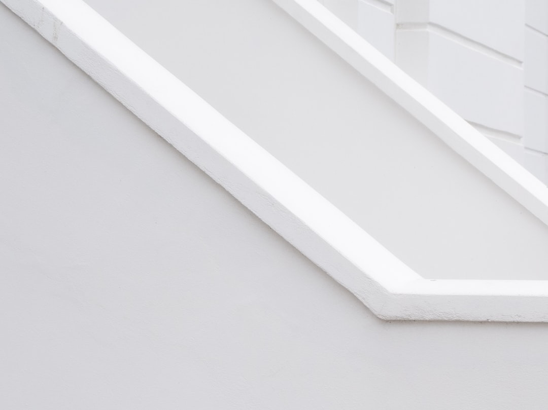 A closeup of the white corner in an empty room, featuring a diagonal composition with a diagonal line of thin and clean lines that resemble stairs or collar beams. The background is pure white, creating a stark contrast to highlight the architectural details. This minimalistic design emphasizes simplicity and elegance through the geometric shape of these straight, uniform lines. by minimalist style, coloring page cartoon drawing –ar 128:95