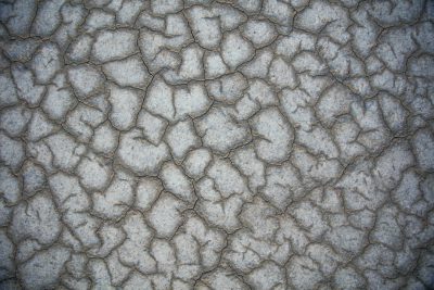 flat gray desert texture, with many small cracks and dust --ar 128:85