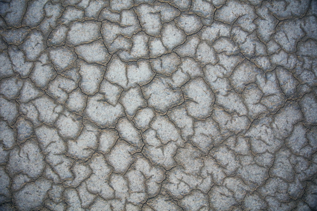 flat gray desert texture, with many small cracks and dust –ar 128:85