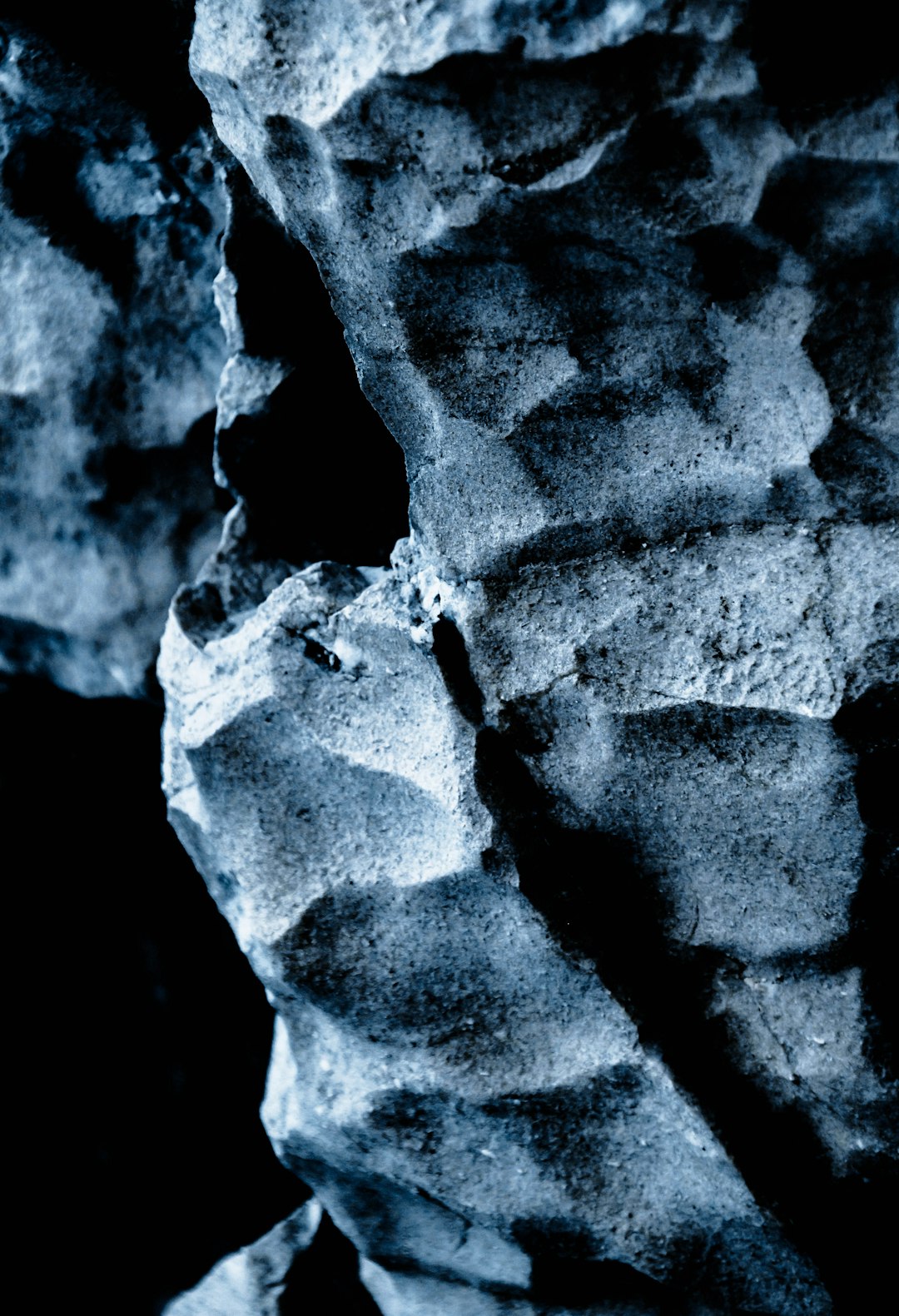 close up texture of rock, monochrome blue tones, dark background, low light, hyper realistic photography –ar 87:128