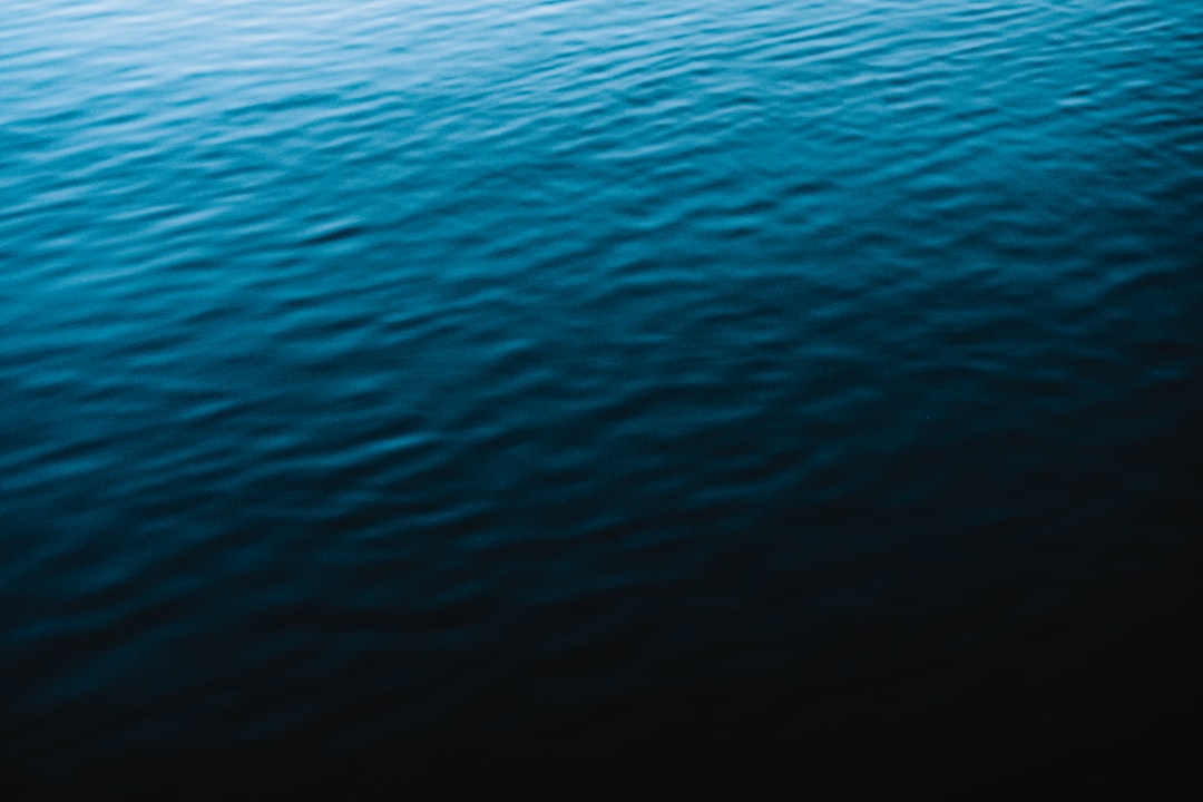 dark blue water texture, close up, flat, with a blurry background, simple, minimalistic, dark, with no light, in the style of hyper realistic, shot on a canon r5 –ar 128:85