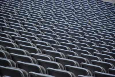 photograph of empty seats in the stands at an outdoor stadium taken with a telephoto lens in natural lighting --ar 128:85