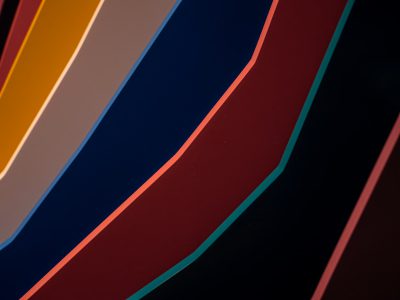 A closeup of the curved edges of an abstract wall, with bold lines in different colors representing circular shapes and gradients. The background is dark to highlight the curves on the surface. --ar 4:3