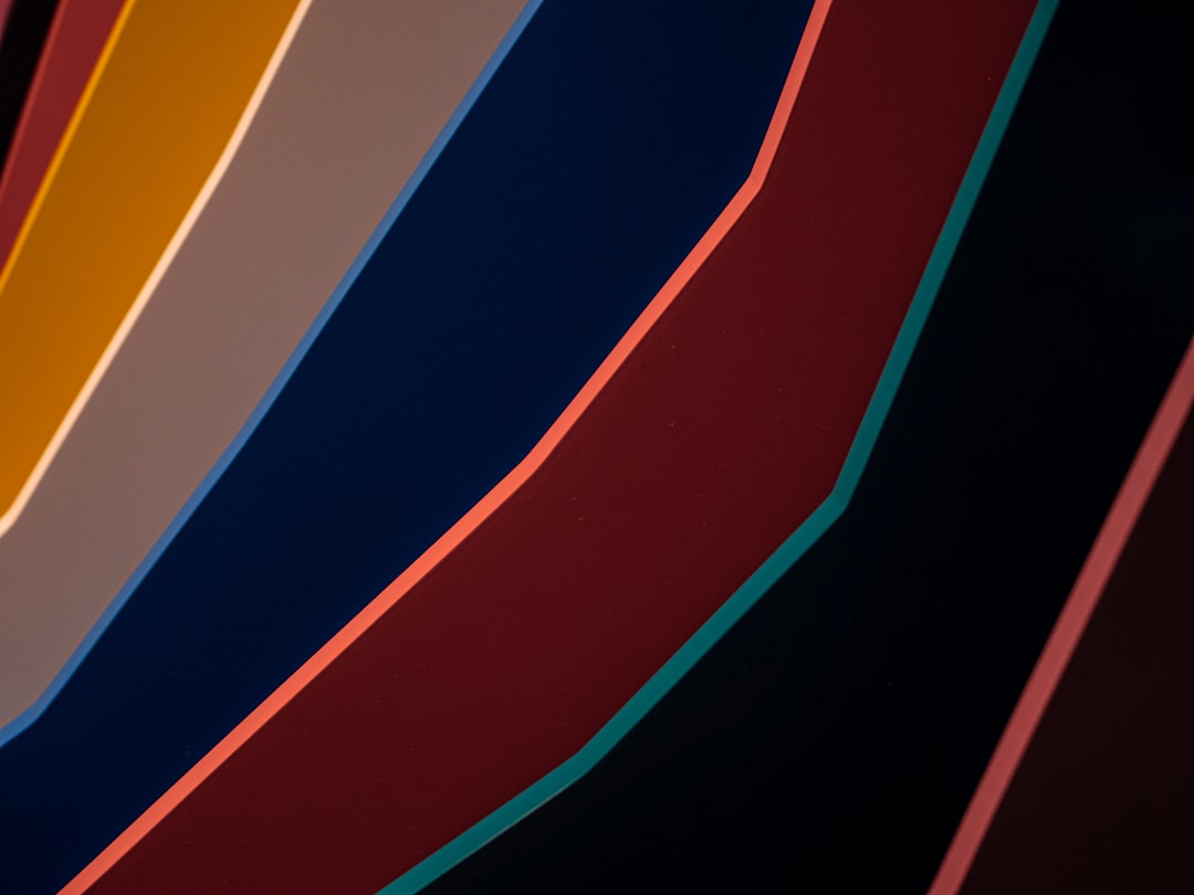 A closeup of the curved edges of an abstract wall, with bold lines in different colors representing circular shapes and gradients. The background is dark to highlight the curves on the surface. –ar 4:3