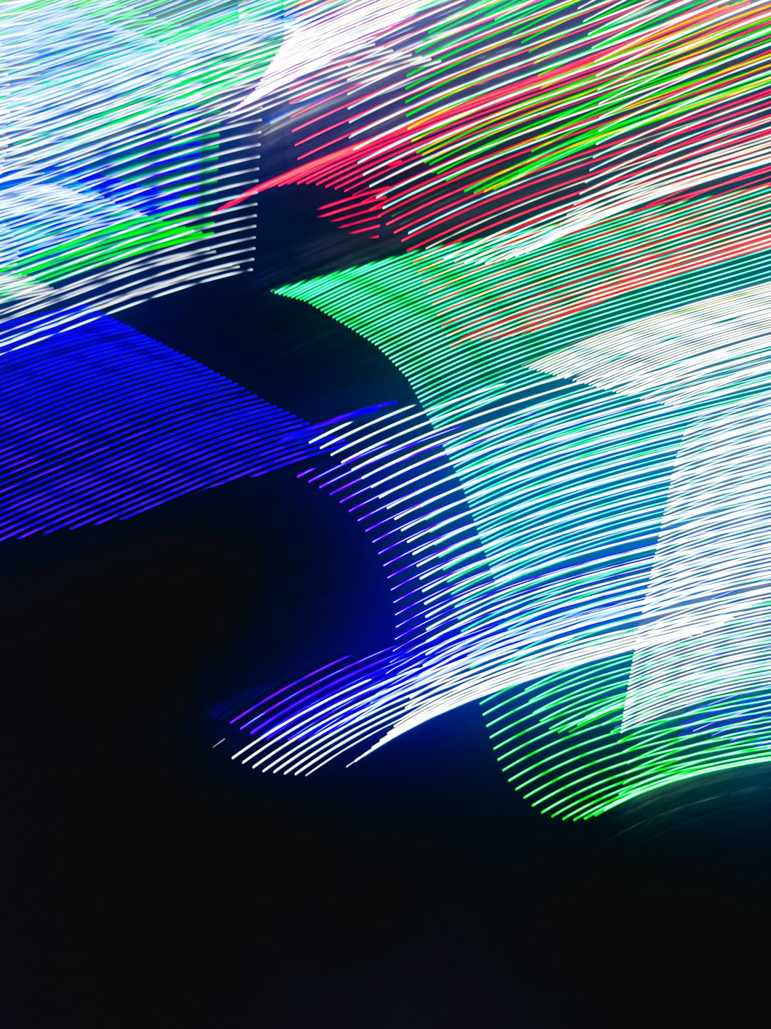 A photo of an abstract composition with lines and shapes in blue, green, white, and red colors on a black background. The lights create long exposure effects that highlight the dynamic movement and energy associated with light painting photography. Abstract photography in the style of light painting. –ar 95:128