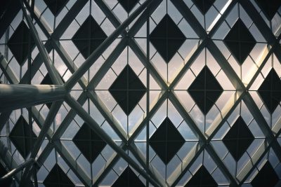 Closeup of the exterior glass curtain wall, diamond shaped grid design with black diamonds and white squares against the sky, the photo taken from an angle at eye level, architectural photography, architectural visualization in the style of Aedas, interior view in perspective with natural light. --ar 128:85