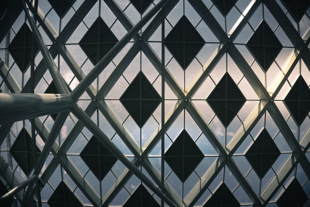 Closeup of the exterior glass curtain wall, diamond shaped grid design with black diamonds and white squares against the sky, the photo taken from an angle at eye level, architectural photography, architectural visualization in the style of Aedas, interior view in perspective with natural light. –ar 128:85