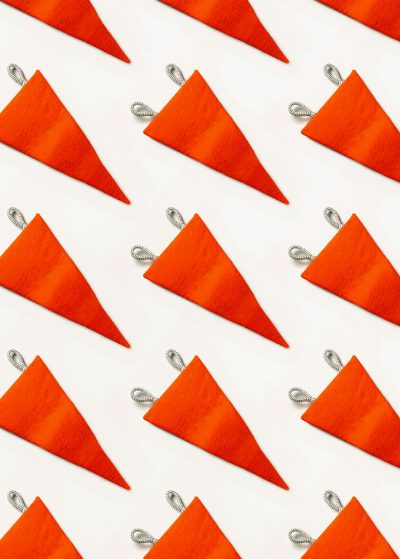 A pattern of small orange triangular fabric flags, with silver edging on the corners and sides, white background, flat lay photography, minimal concept, photographed in the style of art director. --ar 91:128