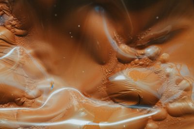 Close up of sand swirling in blurry motion, orange and brown colors. Fluid art in the dreamy style. --ar 128:85