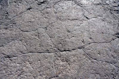 A flat concrete texture with small cracks, top view, close up, in the style of unknown artist. The texture has a worn look with minor fissures. It is a close perspective showing the details of the surface. --ar 128:85