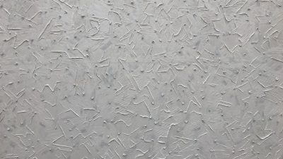 A closeup of the texture on an smooth, gray wall with small and large crisscross lines that resemble splashes or strokes in various sizes. The background is uniform and bright white to highlight details. --ar 16:9