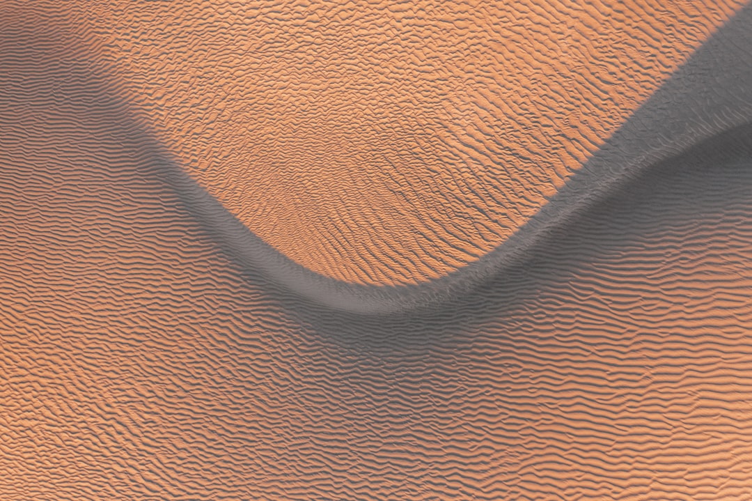 top view of sand dunes, smooth lines, orange and grey, abstract, realistic photography, high resolution, hyperrealistic, detailed –ar 128:85