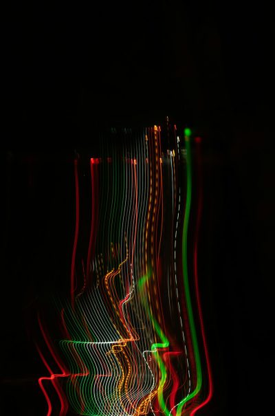 Dark background, long exposure photography, light painting of green and red lines on the screen, curved shape, black background, --ar 21:32