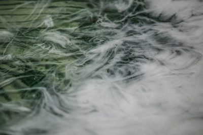 A closeup of green and white thick spider silk, swirling in the air with soft light. The background is blurred and indistinct due to its focus on capturing details. It creates an atmosphere that feels like being surrounded by misty clouds or flowing water, adding depth and texture to the scene. This is suitable for creative projects where detail is objects like fabrics, , fur etc . can be used. --ar 128:85