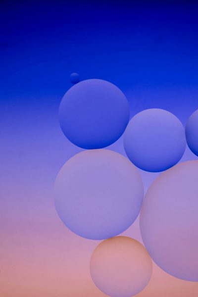 A closeup of large, round balloons floating against the backdrop of a blue sky at sunset. The balloons have various shades and sizes, creating an abstract composition that captures movement and light. This minimalistic scene embodies tranquility with its clean lines and serene atmosphere. It's perfect for mobile wallpaper or background in different colors, adding depth to your phone screen in the style of minimalism. --ar 85:128