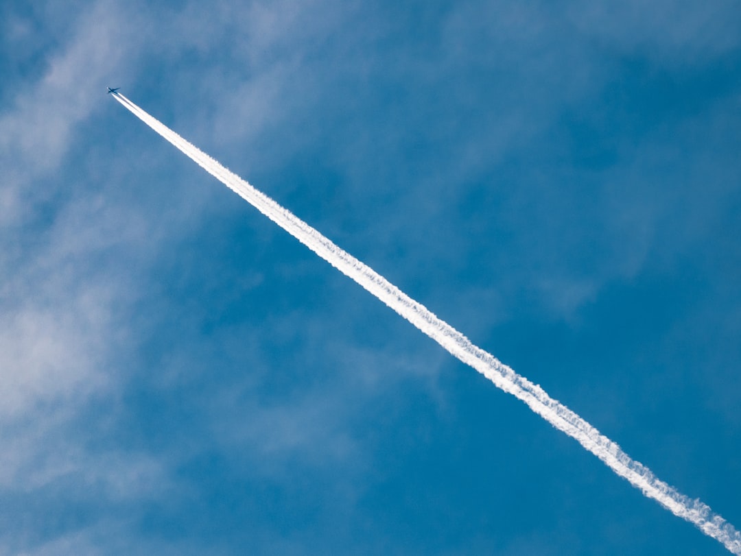 A straight line of white smoke from an airplane in the blue sky, leaving behind it as if a trail had been drawn. The picture is taken with Canon EOS camera, ISO800, f/24, with professional lighting and professional color grading, making for a clean and high-quality appearance. –ar 4:3