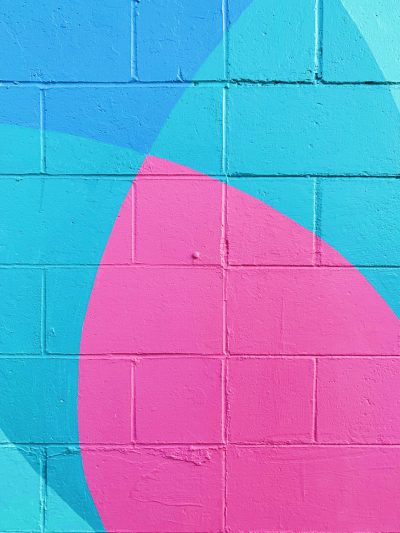 Pink and blue wall with a simple pink circle, simple shapes, in the style of a mural, light turquoise and sky blue tones, bright colors, in the style of street art, with a brick texture, a vibrant and playful mood, a closeup shot, with high resolution and clear details. --ar 3:4