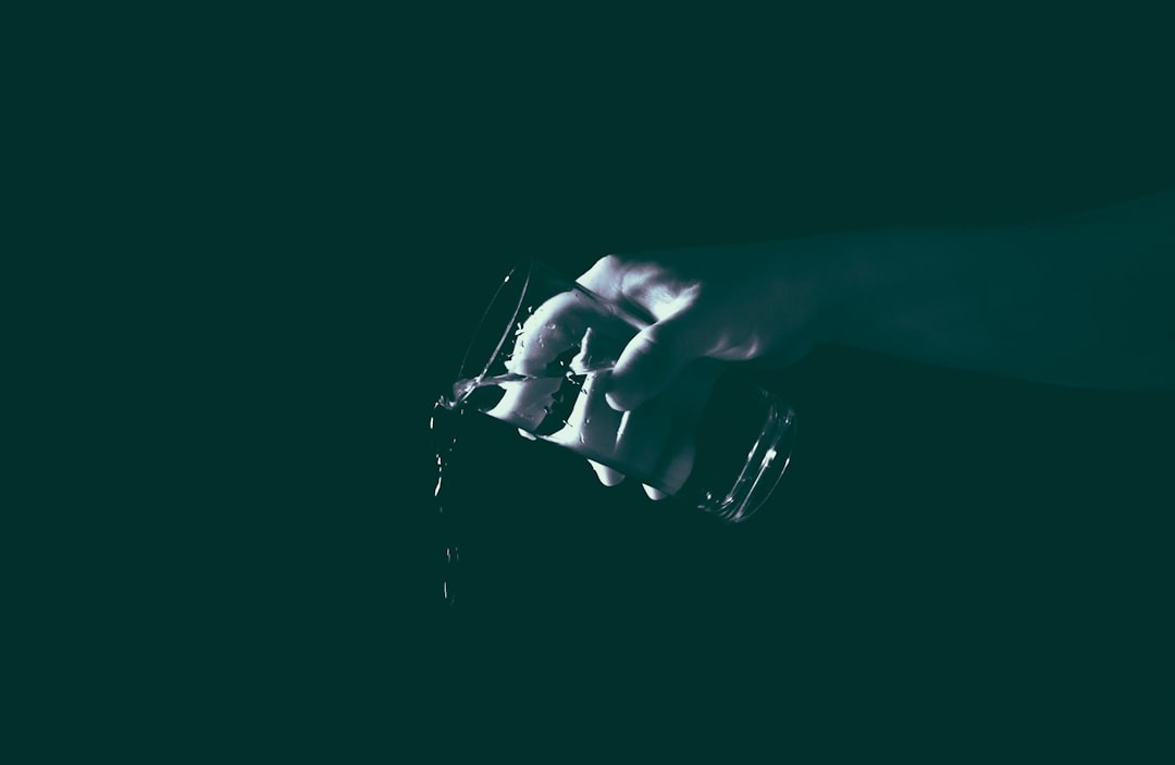 dark background, close up of a hand holding a camera in low light, white and dark green colors, minimalism, cinematic style –ar 128:83