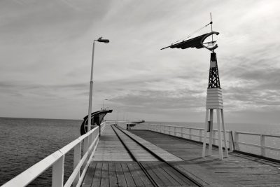 Black and white photograph of the old pier in Road to Py Moskvy, a wind vane on one side of the pier, in the style of by unknown artist. --ar 128:85