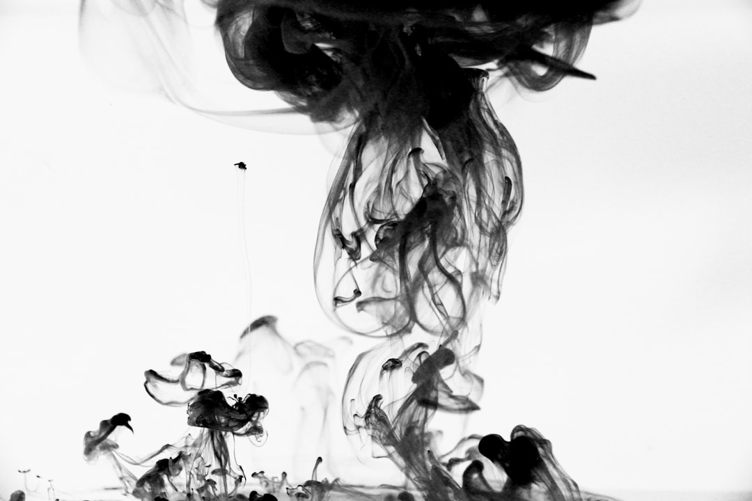 Black ink in water, smoke, white background, photography style, simple and clean composition, high definition, high resolution, high detail, black smoke, smoke swirling around the middle of an abstract shape, with a few small flowers scattered on it. The ink is flowing from top to bottom, creating a dynamic feeling. High contrast between light and dark tones creates visual impact. A wideangle lens captures entire picture. Black ink floats at different heights, forming an interesting pattern. It’s like liquid art. –ar 128:85