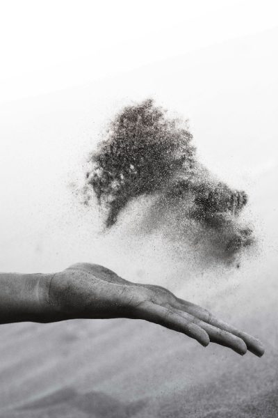 Black and white photography of sand particles being thrown from the palm into air, minimalism --ar 85:128