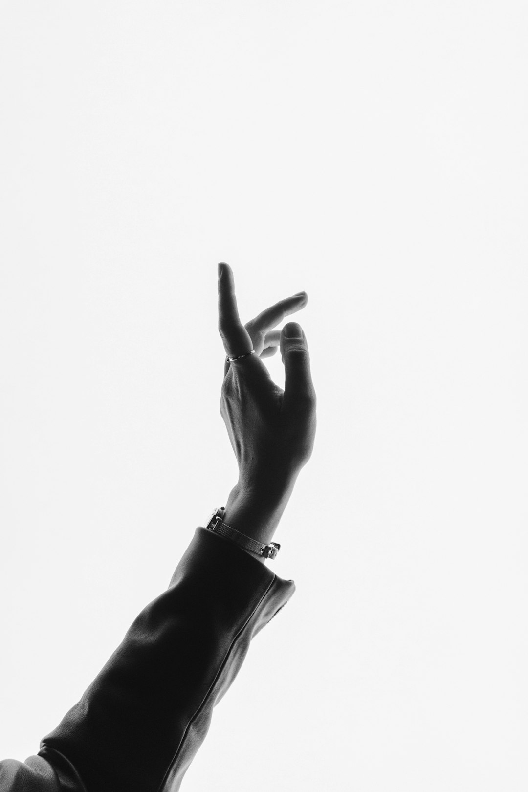 A hand in the air, pointing to something on a white background, minimalistic, monochrome, high contrast, fashion photography, luxury style, editorial, in the style of a fashion magazine cover. –ar 85:128