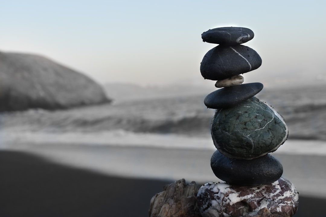 A photo of a stack of rocks balanced on top of each other, creating an artistic sculpture at the beach. Web banner with empty space on the right side in the style of copyspace. –ar 128:85