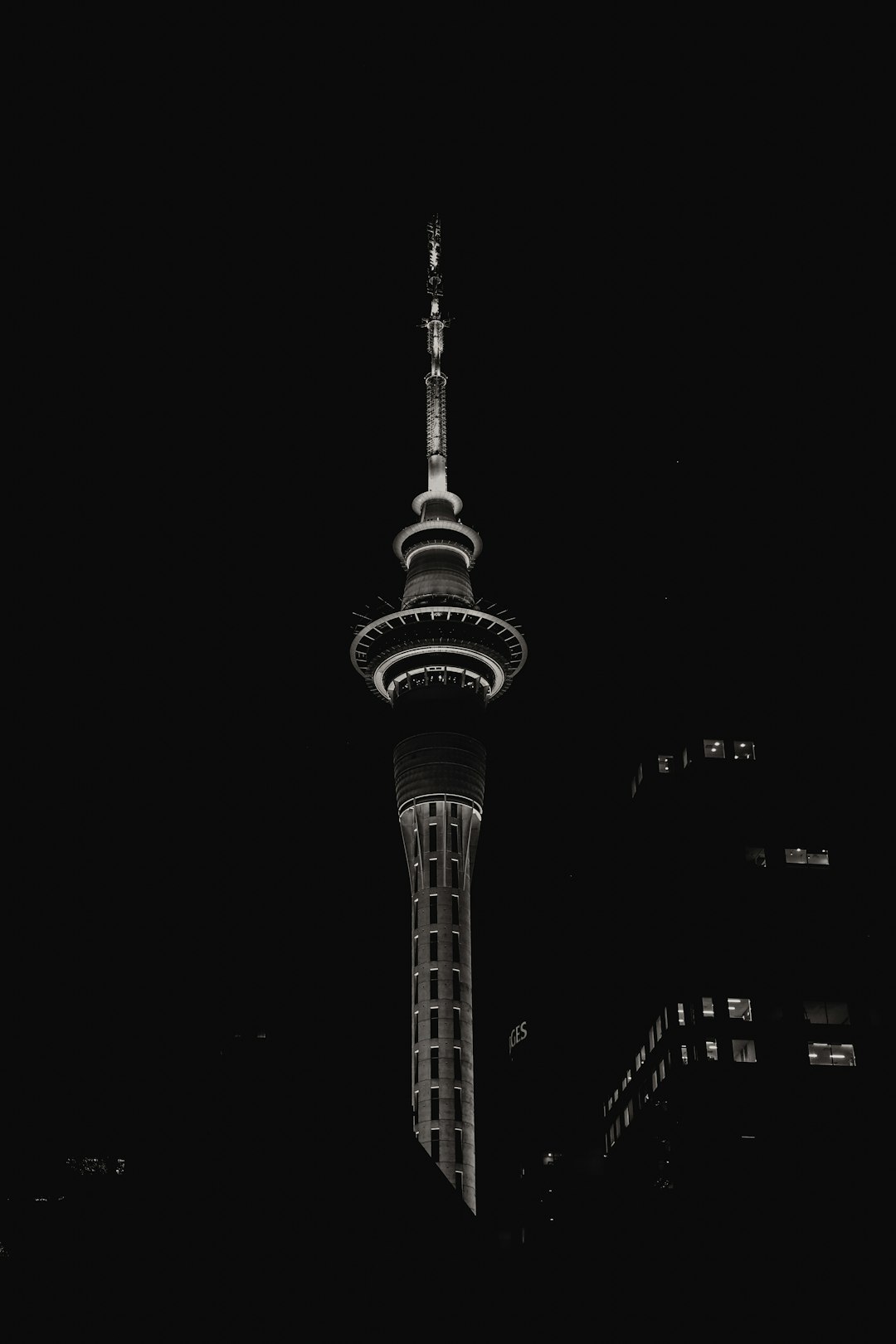 black and white photo of the sky tower in new zealand, night time, high contrast, minimalistic, black background, cinematic, artful, professional photography, high resolution, canon r5 –ar 85:128