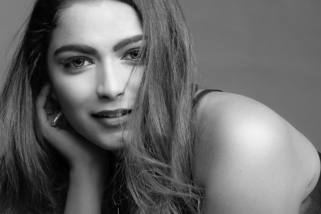 black and white studio portrait of beautiful woman with long hair, posing for the photo, shot in the style of Sony Alpha A7 III –ar 128:85