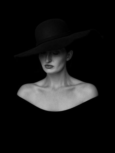 Black and white portrait of woman with hat, high contrast, minimalism, award winning photography in the style of amazing photographer. --ar 3:4