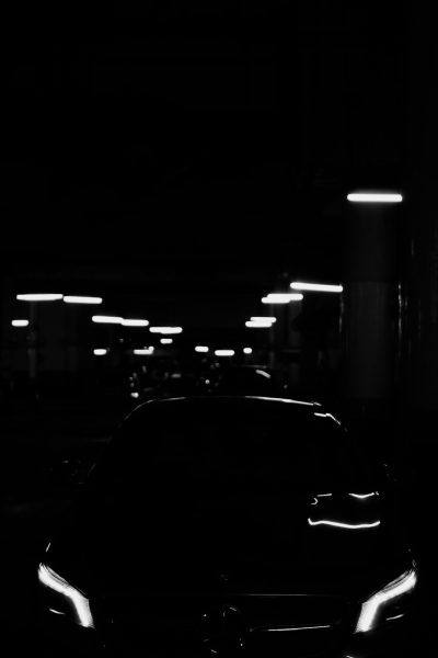 a black and white photo of the silhouette of an all electric mercedes e63s in a dark parking lot, lit by street lights, minimalist, clean lines, high contrast, negative space --ar 85:128